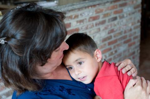 Kind met autisme ligt dicht bij mama om rustig te worden